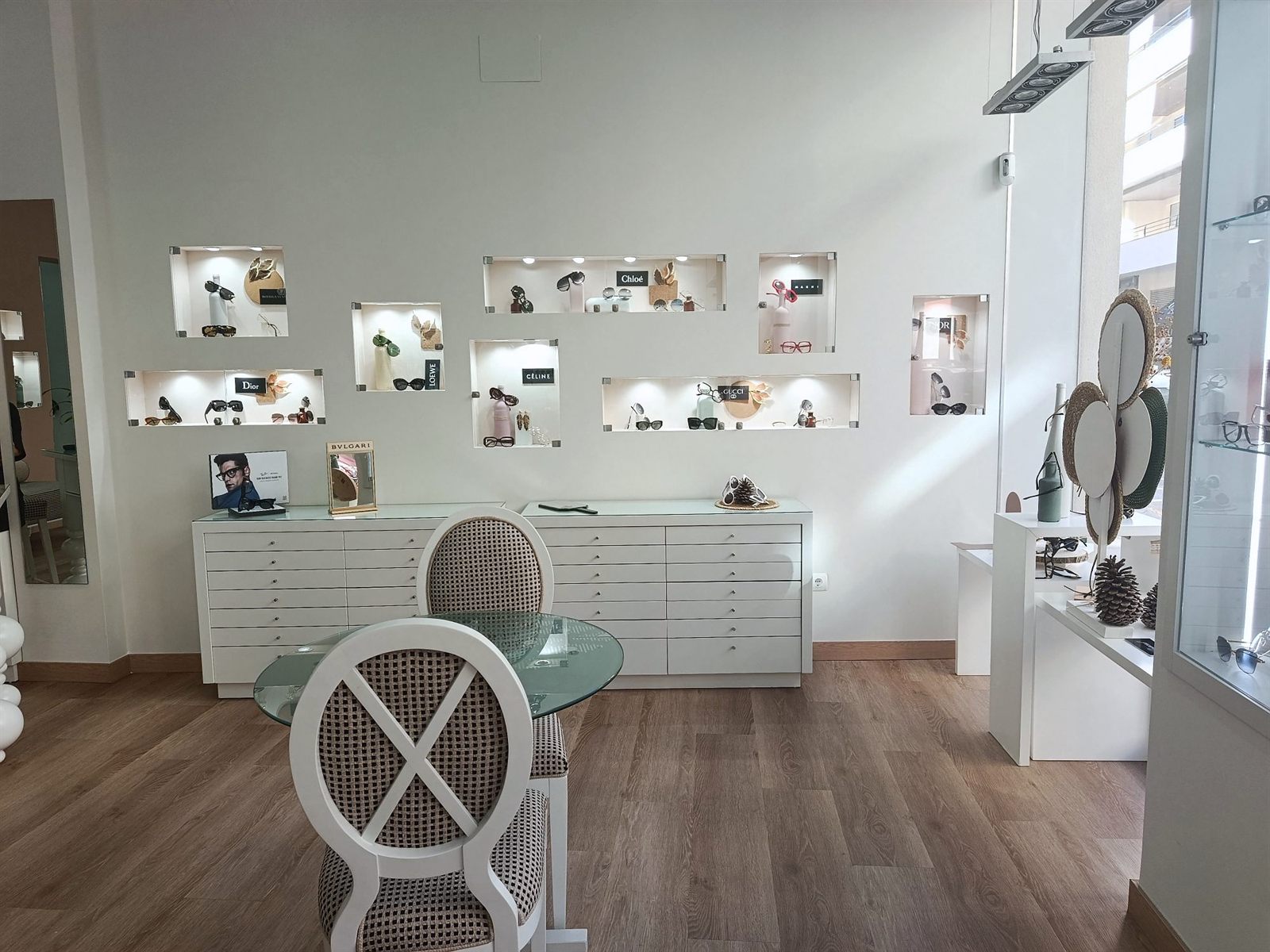 Hornacinas iluminadas con gafas de Dior, Chloé, Loewe, Céline, Gucci y Marni, y mesa de atención